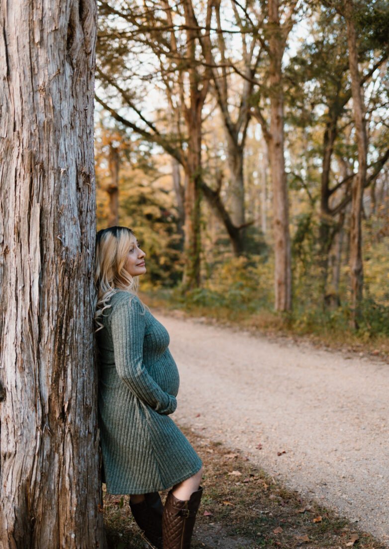 DMV maternity photographer capturing a candid fall lifestyle maternity photo of a pregnant woman outdoors in natural light.